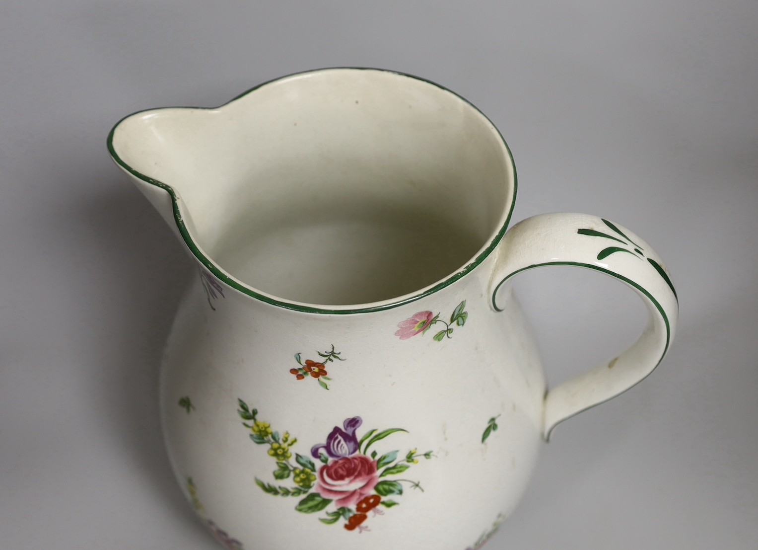 A Pountney jug, commemorating 100 years of the Bristol porcelain factory 1770 -1781, decorated with floral sprays and sprigs, green line border, 27cm high, printed mark. 26.5cm